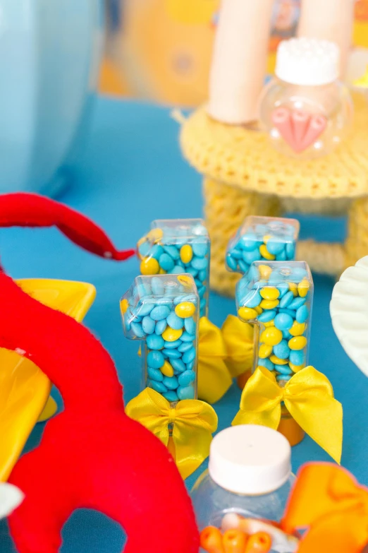 a close up of a plate of food on a table, little mermaid, blue theme and yellow accents, candy, vibrant vials