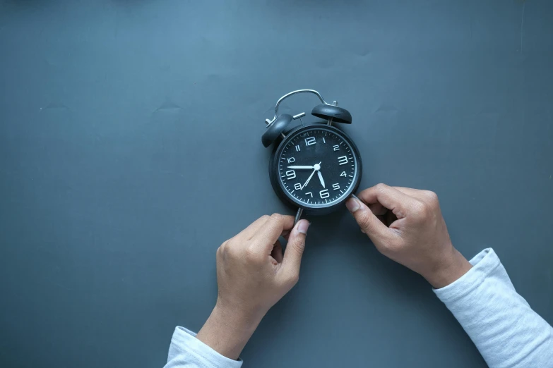 a close up of a person holding an alarm clock, happening, on a gray background, local conspirologist, it's getting dark, profile image