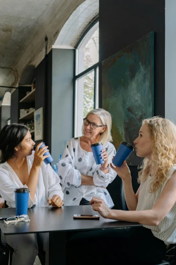 a group of women sitting around a table talking, pexels contest winner, blue accents, aussie baristas, hydration, environment