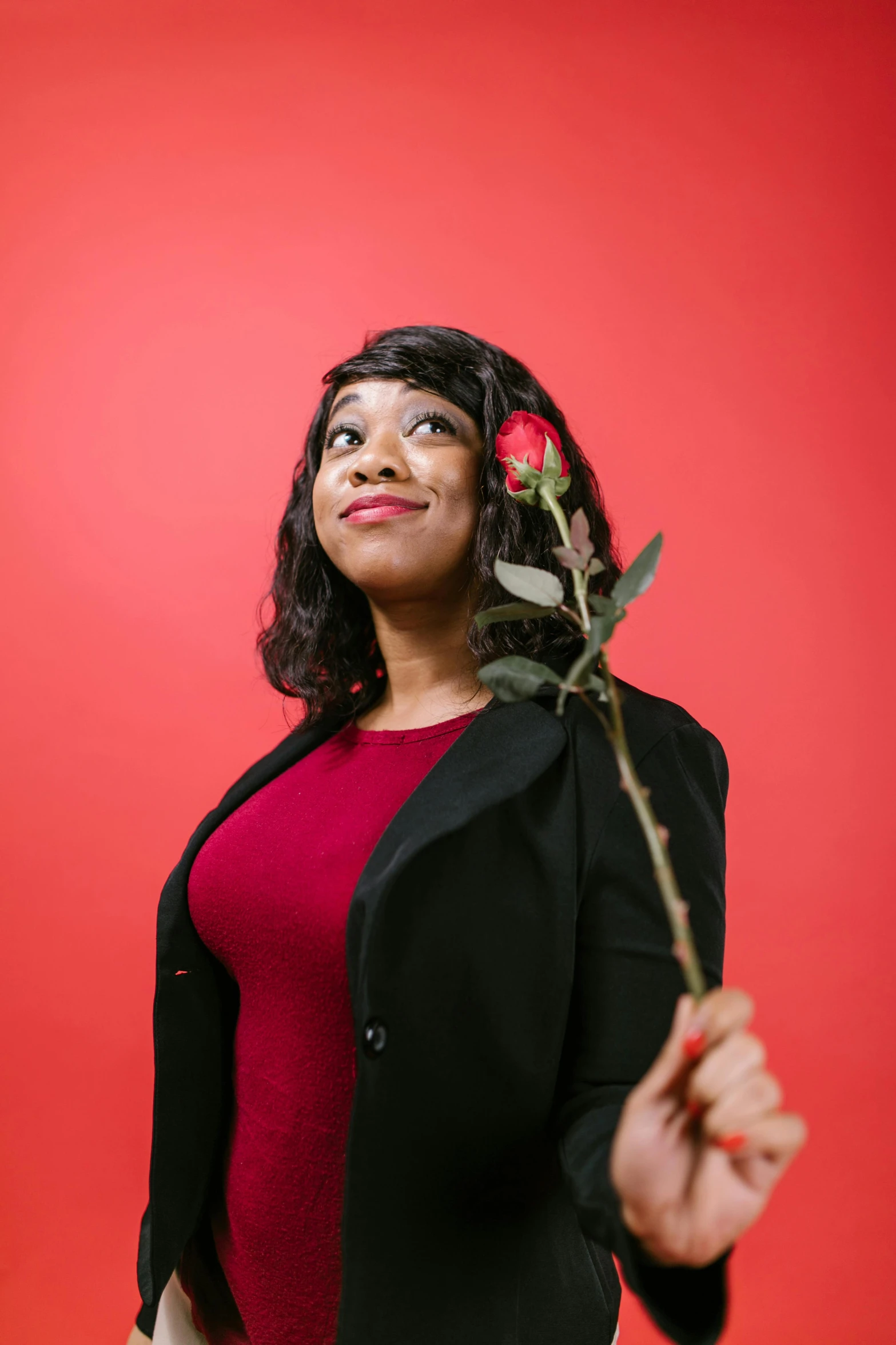 a woman with a rose in her hand, an album cover, by Winona Nelson, trending on unsplash, in red background, african american young woman, a handsome, museum quality photo