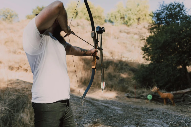 a man that is standing in the dirt with a bow, profile image