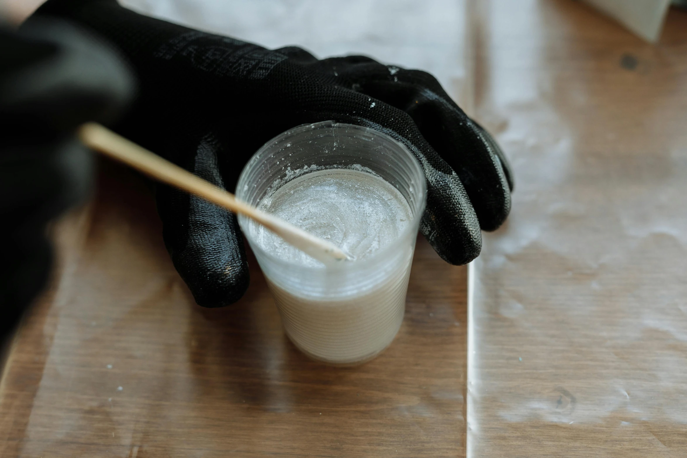 a person holding a toothpick over a cup of liquid, unsplash, plasticien, covered in white flour, on a wooden tray, pearlescent skin, inuit