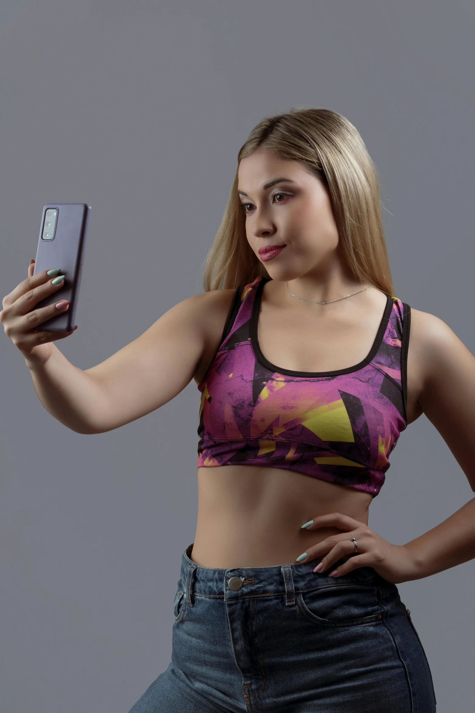 a woman taking a selfie with her cell phone, by John Luke, holography, sports bra, no - text no - logo, galactic yellow violet colors, croptop