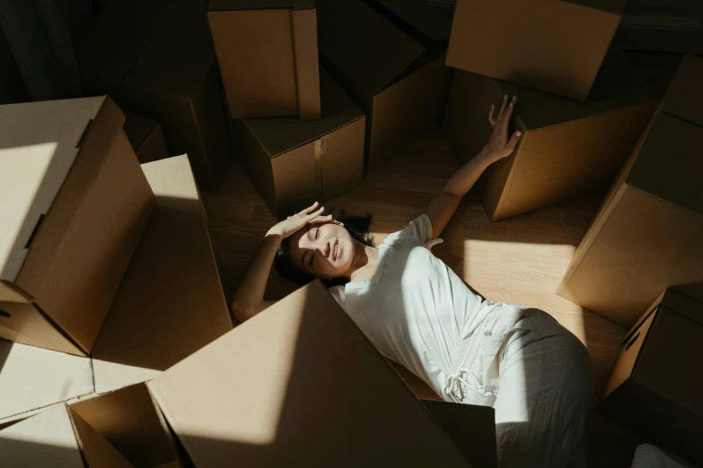 a woman laying on the floor surrounded by boxes, pexels contest winner, renaissance, avatar image, devastated, sunlit, thumbnail