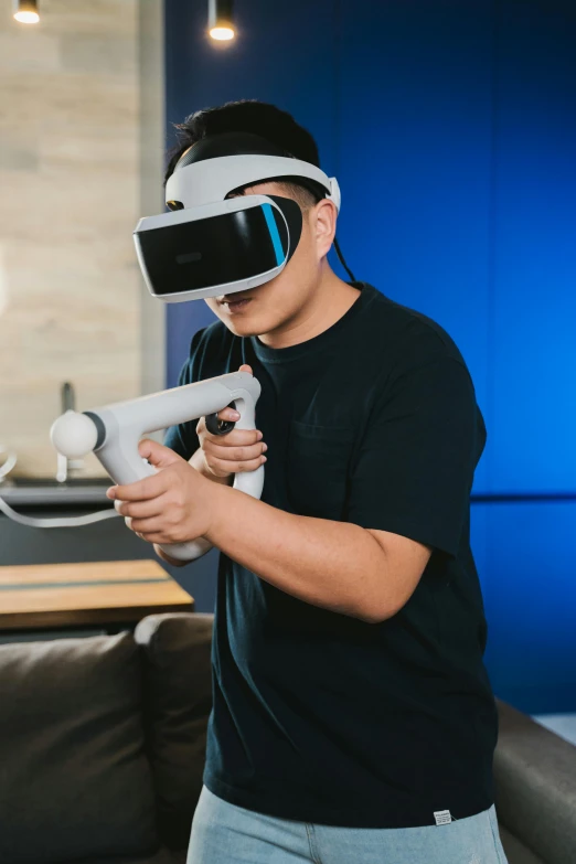 a man standing in a living room holding a video game controller, a hologram, inspired by Leng Mei, altermodern, oculus quest 2, shot with sony alpha, little kid, sleek oled blue visor for eyes