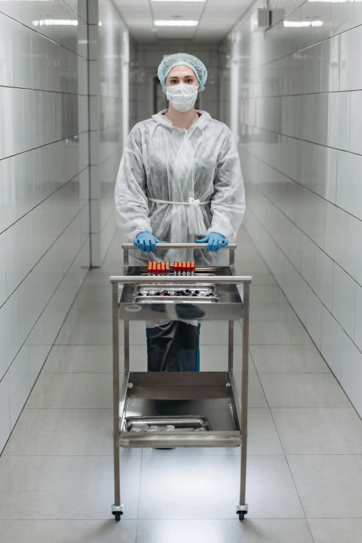 a person standing next to a table with food on it, surgical implements, liquid metal, manufacturing, cart