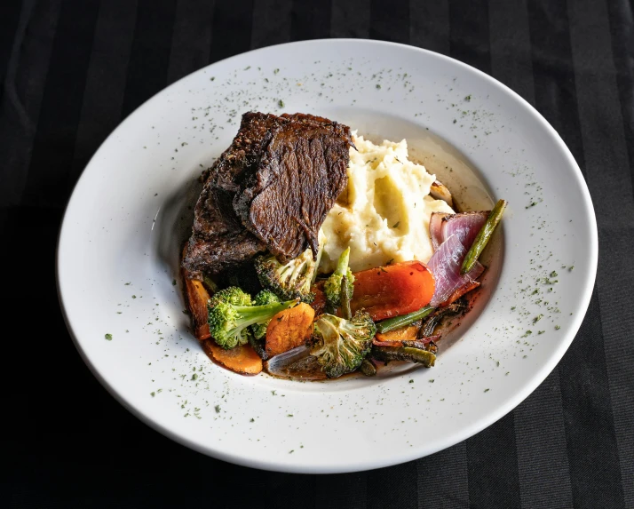 a close up of a plate of food on a table, bull head, thick bow, mashed potatoes, lush vista