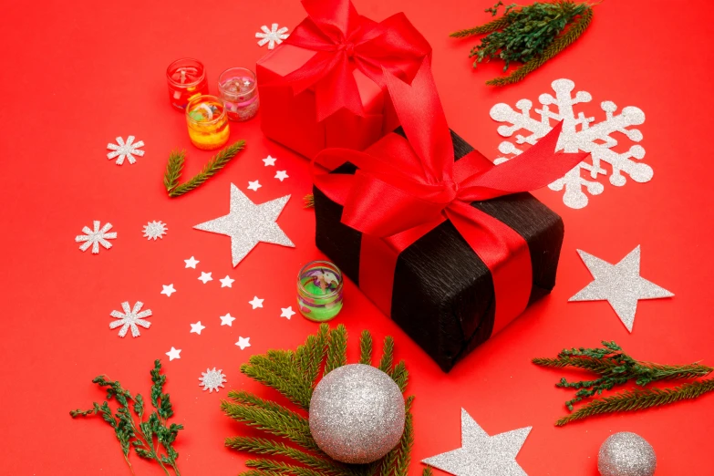 a black gift box sitting on top of a red table, by Julia Pishtar, pexels contest winner, process art, organic ornaments, bows, background image, various items