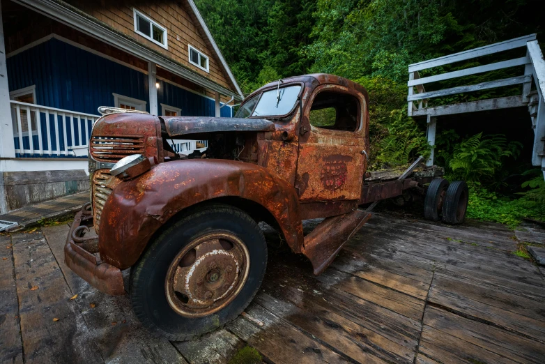 an old rusted truck parked in front of a house, a portrait, pexels contest winner, haida gwaii, mining outpost, a wooden, 4k/8k