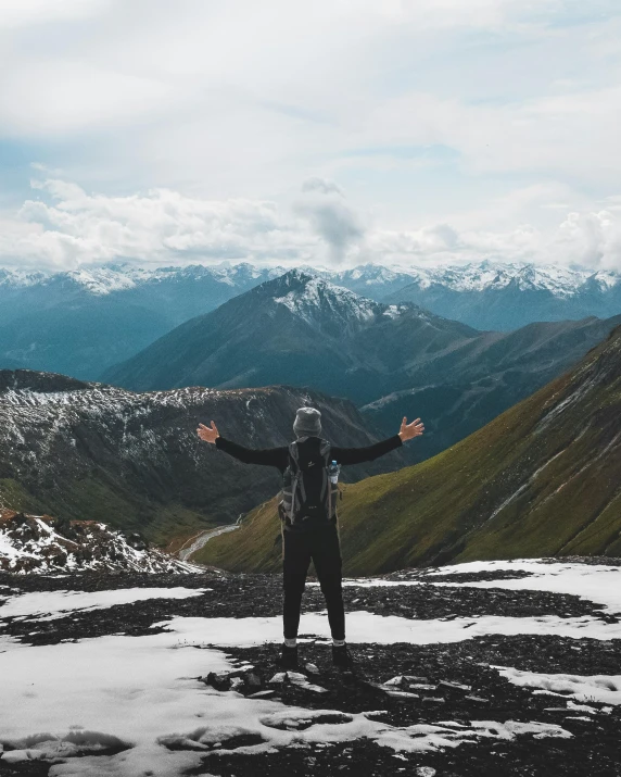 a person standing on top of a snow covered mountain, by Jessie Algie, pexels contest winner, shrugging arms, trending on vsco, wearing dirty travelling clothes, looking off into the distance