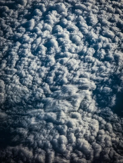 a plane flying through a cloudy blue sky, an album cover, by Greg Rutkowski, unsplash, nasa footage, mammatus clouds, ☁🌪🌙👩🏾, leaked from nasa