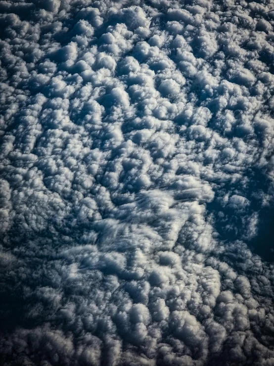 a plane flying through a cloudy blue sky, an album cover, by Greg Rutkowski, unsplash, nasa footage, mammatus clouds, ☁🌪🌙👩🏾, leaked from nasa