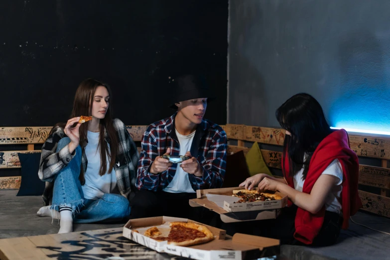 a group of people sitting on the ground eating pizza, trending on pexels, renaissance, wearing jeans and a black hoodie, sitting in a lounge, profile image, hollywood promotional image