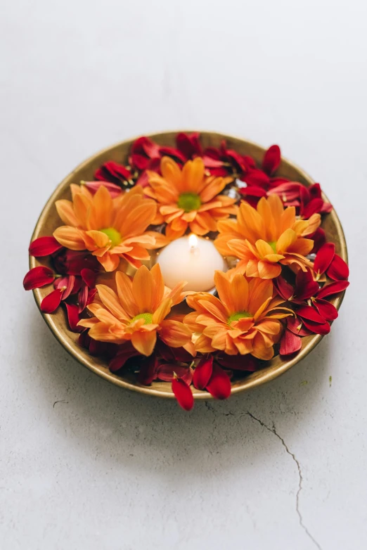 a bowl filled with flowers and a candle, orange halo, indian style, full product shot, centerpiece