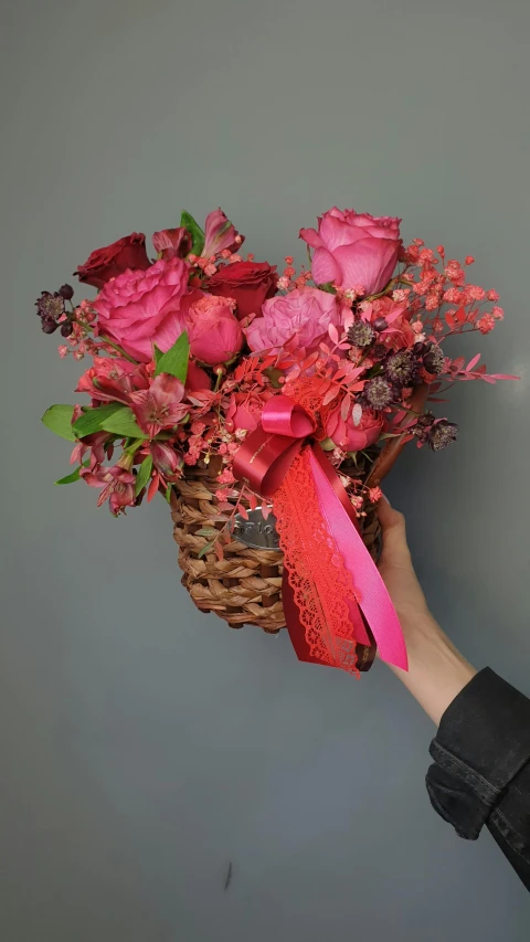 a close up of a person holding a basket of flowers, pink and red color scheme, vista view, facing front, vine