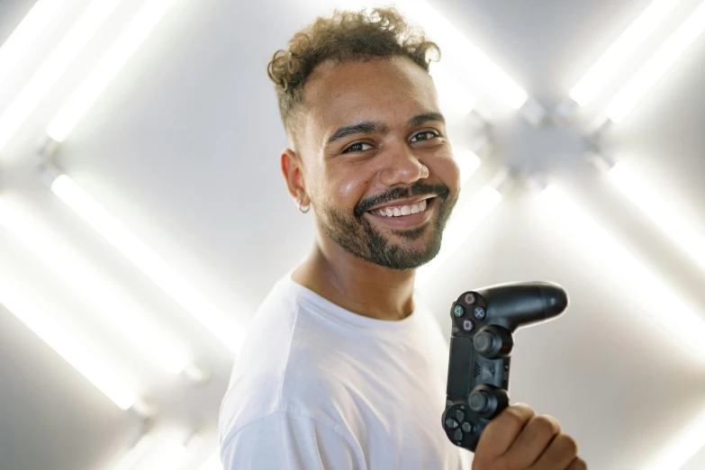 a man holding a video game controller in his hand, pexels contest winner, happening, brown skin man with a giant grin, light beard, photo from a promo shoot, lachlan bailey