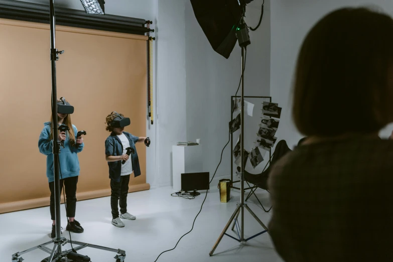 a couple of people that are standing in a room, wearing vr, studio photoshoot, children, future coder looking on