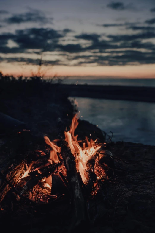 a close up of a fire near a body of water, by Niko Henrichon, unsplash contest winner, romanticism, dusk light, camp, album cover, multiple stories