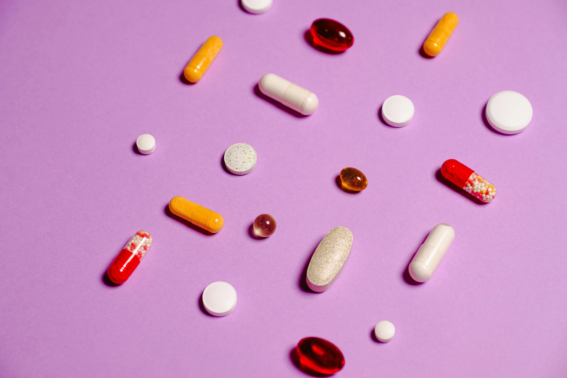 a bunch of pills sitting on top of a purple surface, by Julia Pishtar, ingredients on the table, a brightly coloured, goop, mid riff