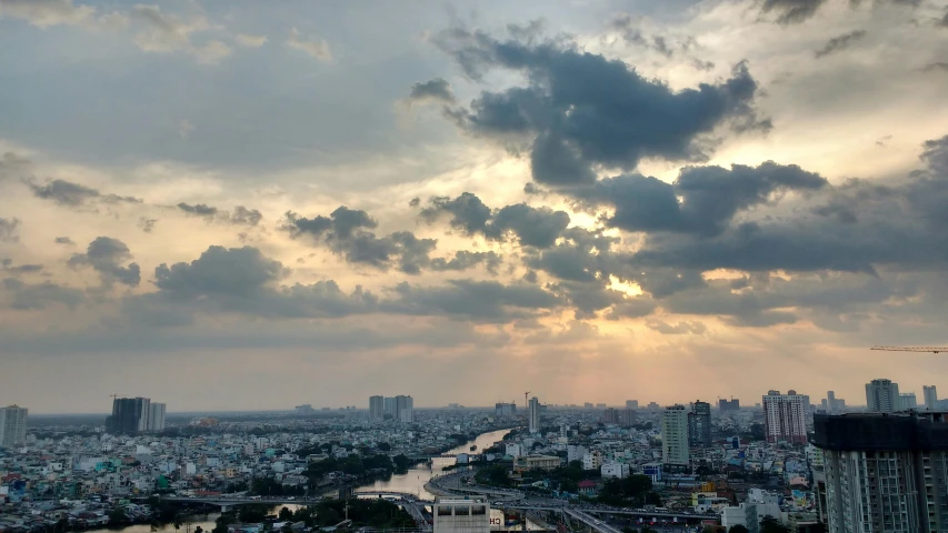 a river running through a city next to tall buildings, pexels contest winner, hazy sunset with dramatic clouds, bangkok, today\'s featured photograph 4k, partly cloudy sky