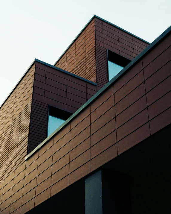 a close up of a building with a clock on it's side, an album cover, inspired by David Chipperfield, unsplash contest winner, brown:-2, sharp geometrical squares, exterior view, sustainable materials