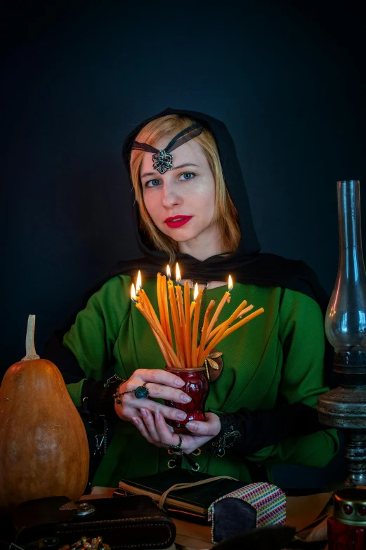 a woman dressed as a witch holding a candle, a character portrait, inspired by Limbourg brothers, reddit, cosplay photo, crystal maiden, wearing dark green robes, she is a gourd