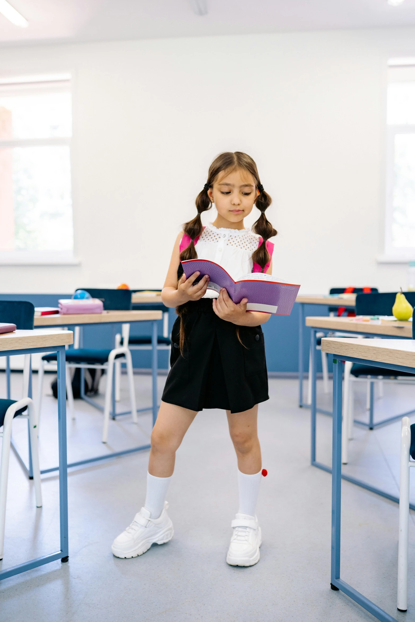 a little girl reading a book in a classroom, pexels contest winner, danube school, standing on two legs, parody, inspect in inventory image, giving a speech
