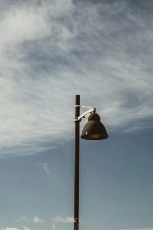 a street light sitting on the side of a road, unsplash, postminimalism, summer sky, high resolution photo, ignant, bells