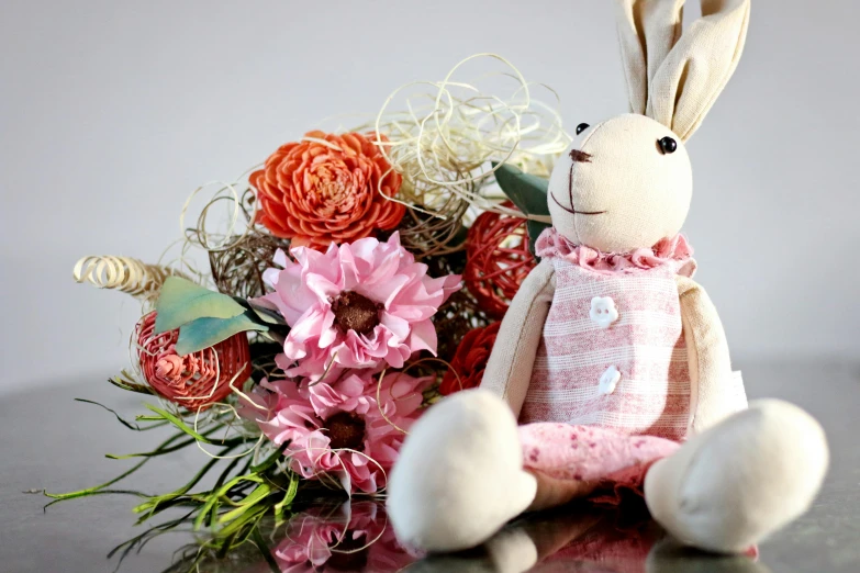 a stuffed rabbit sitting next to a bouquet of flowers, pink, artisanal art, high quality product image”, pink orange flowers