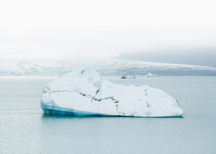 a large iceberg floating in the middle of a body of water, pexels contest winner, icy cold pale silent atmosphere, white lava, minimalist rule of thirds, fan favorite