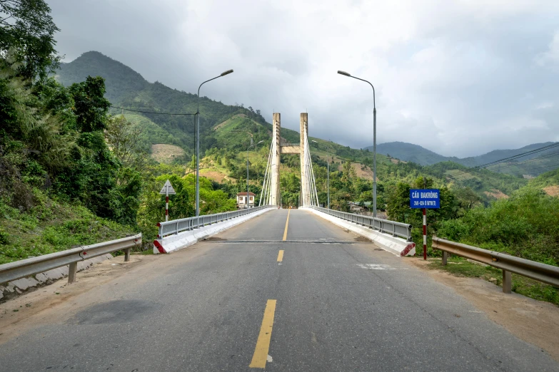 a view of a bridge with mountains in the background, by Ceferí Olivé, unsplash, hurufiyya, shipibo, helio oiticica, flat roads, slide show