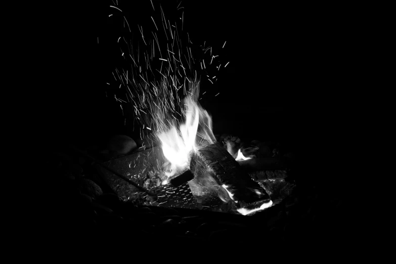 a black and white photo of a campfire, a black and white photo, by Caroline Mytinger, golden embers flying, frying nails, mixed art, uploaded