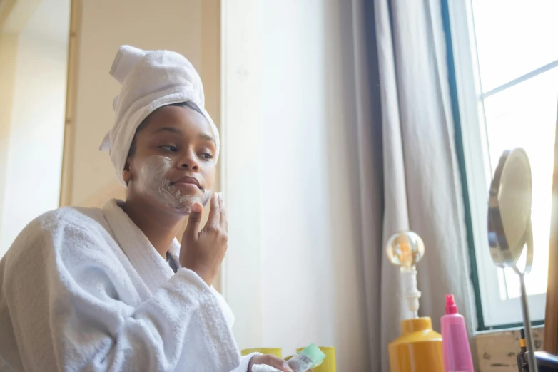 a woman in a bathrobe brushing her teeth, by Julia Pishtar, pexels contest winner, portrait of ororo munroe, skin care, shaved face, thumbnail