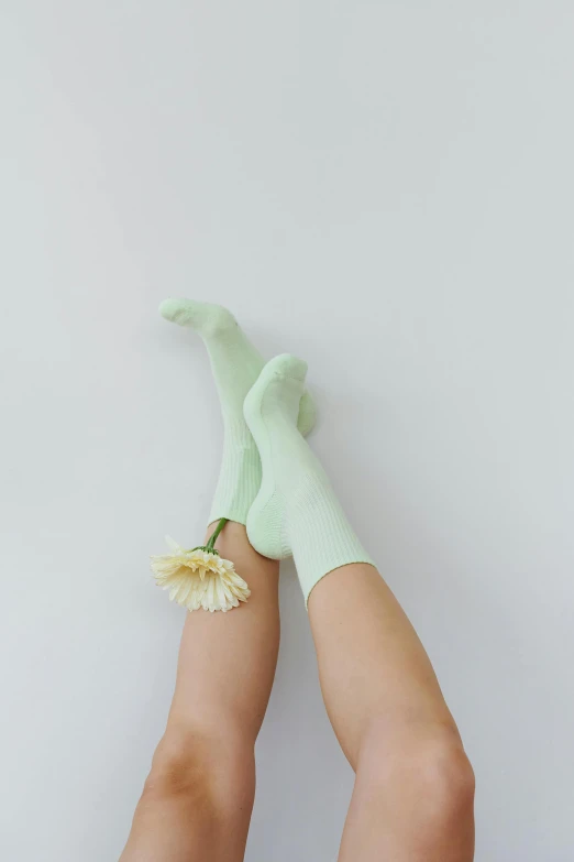 the legs of a woman wearing green socks, unsplash, minimalism, pastel green, blooming, full product shot, lumi