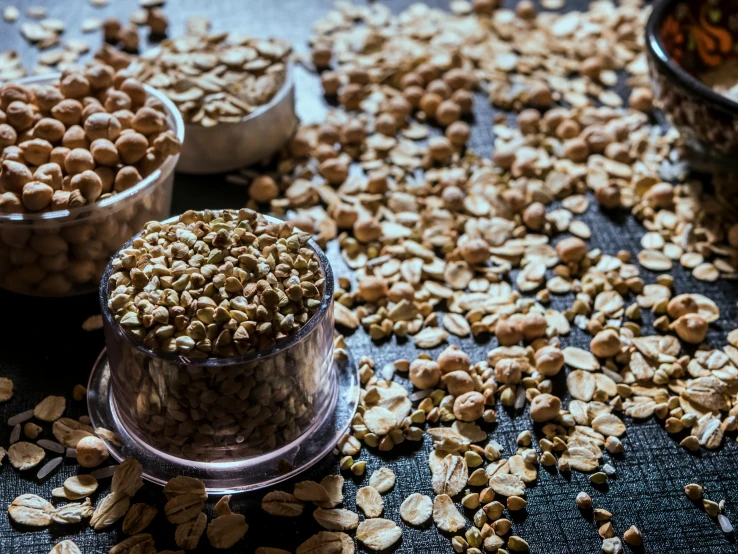 a bunch of nuts sitting on top of a table, a portrait, by Julia Pishtar, trending on pexels, mineral grains, hemp, jars, background image