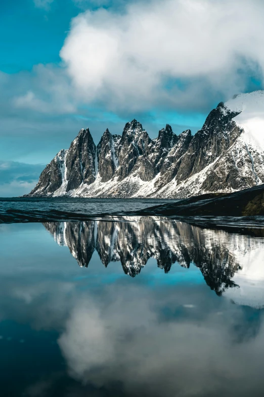 a mountain reflected in the water of a lake, by Sven Erixson, pexels contest winner, baroque, devils horns, snowy arctic environment, asymmetrical spires, full frame image