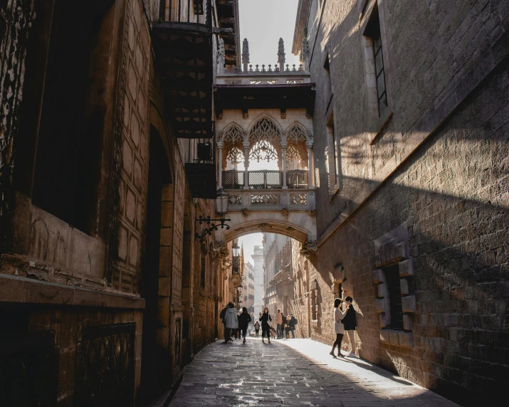 a group of people walking down a narrow street, inspired by Modest Urgell, pexels contest winner, baroque, sweeping arches, sunlight glistening, thumbnail, gothic architecture