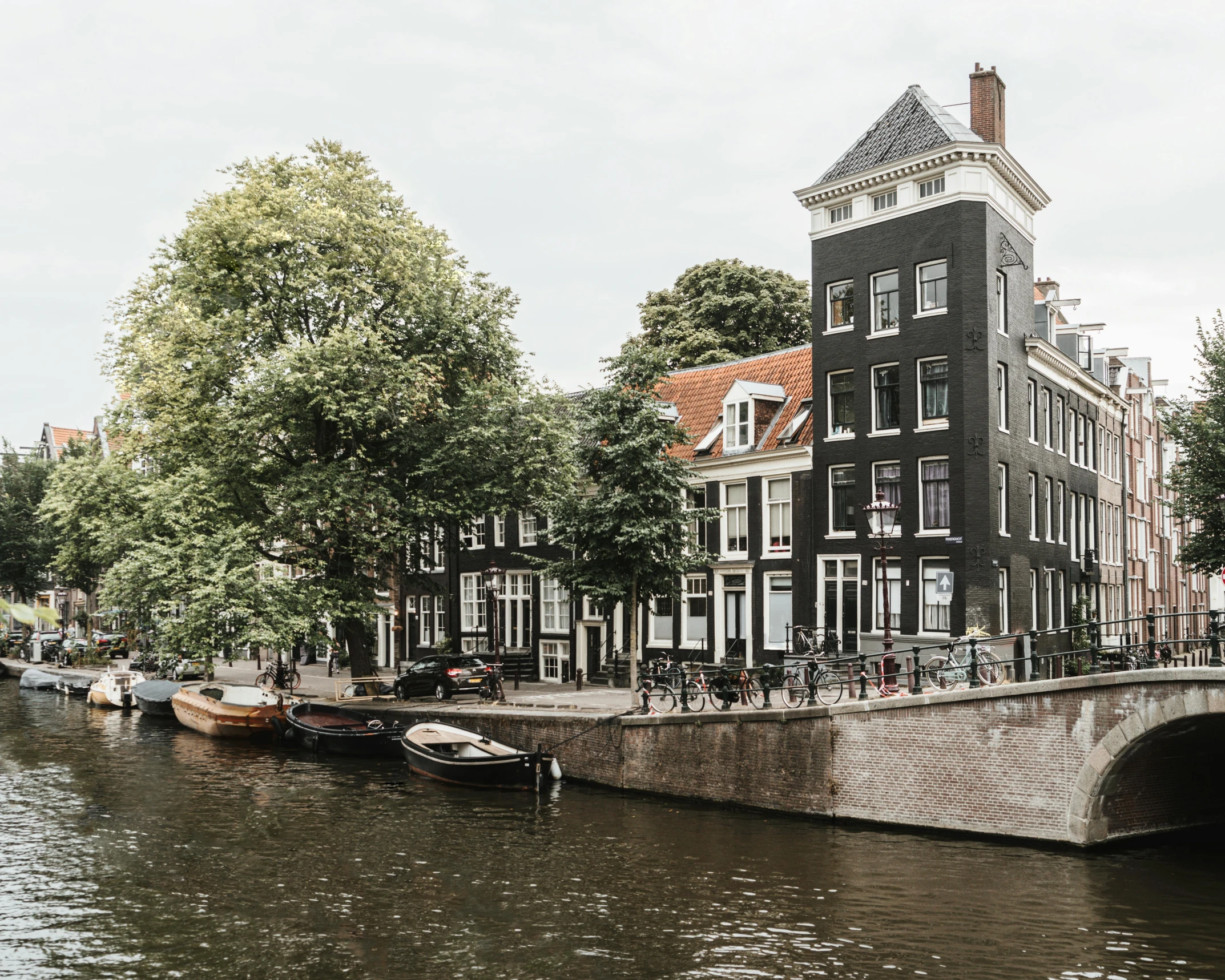 a boat traveling down a river next to a bridge, by Jan Tengnagel, pexels contest winner, neoclassicism, dutch houses along a river, black house, 🦩🪐🐞👩🏻🦳, skyscrapers with greenery