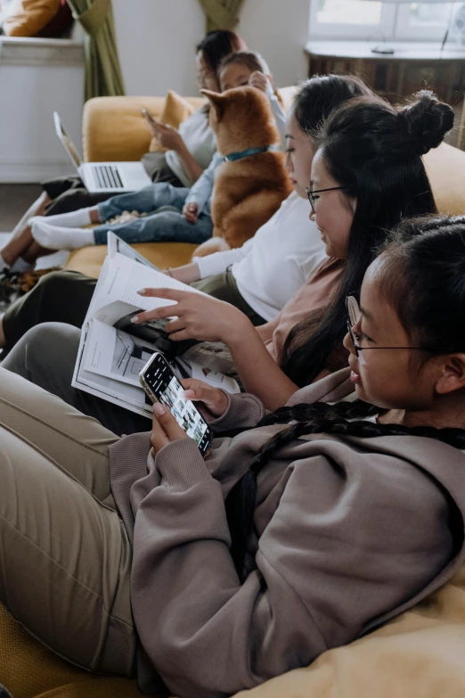 a group of people sitting on a couch with laptops, by Robbie Trevino, trending on pexels, happening, teenage girl, asia, shot on iphone 1 3 pro, reading