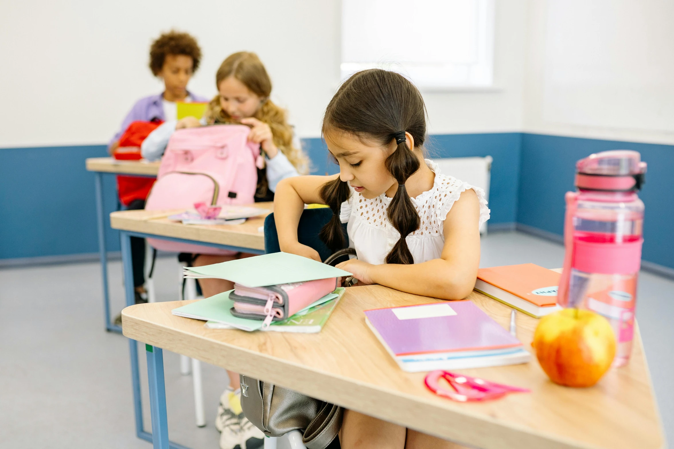 a group of children sitting at desks in a classroom, trending on pexels, girl wearing uniform, with a backpack, alana fletcher, thumbnail