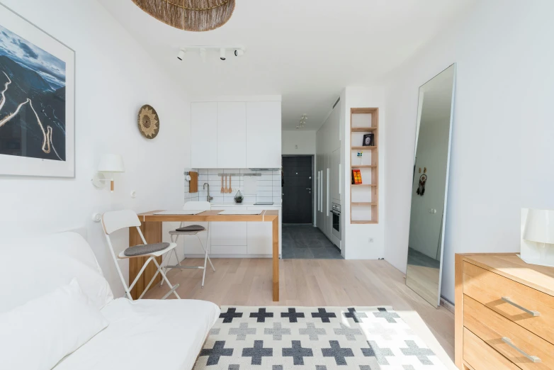 a white couch sitting in a living room next to a wooden table, by Adam Marczyński, pexels contest winner, light and space, small and cosy student bedroom, dwell, white tile on the floor, construction