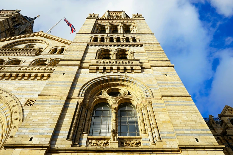 a tall building with a clock on the front of it, romanesque, natural history, victoriana, buttresses, more