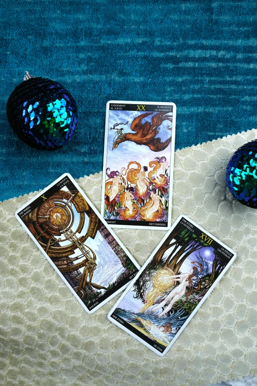a couple of cards sitting on top of a table, octopus wrestling with a sphere, emitting light ornaments, flatlay, mermaids