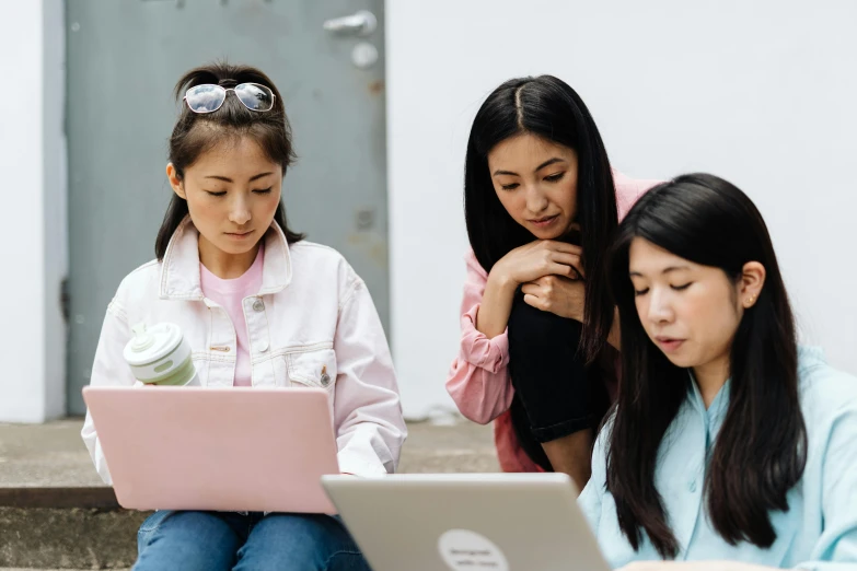 three women sitting on steps looking at a laptop, trending on pexels, ethnicity : japanese, schools, brittney lee, centralised