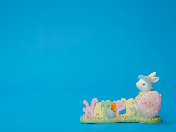 a close up of a figurine on a blue surface, easter, crawling towards the camera, vibrant scene, product display photograph