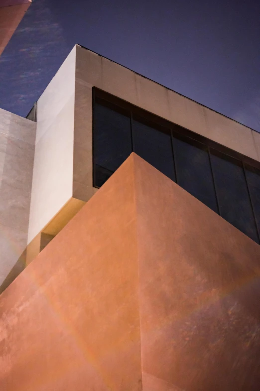 a close up of a building with a sky background, an abstract sculpture, inspired by Ricardo Bofill, copper, james turrell, evening light, stucco walls