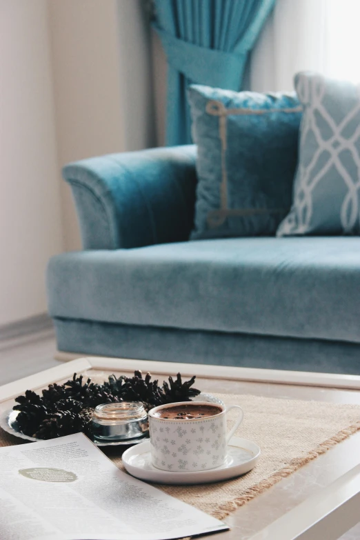 a blue couch sitting in a living room next to a coffee table, inspired by Riad Beyrouti, pexels contest winner, blue soft details, shot with premium dslr camera, pale cyan and grey fabric, high angle close up shot