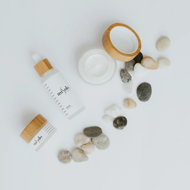 various skin care products laid out on a white surface, unsplash, dau-al-set, pebbles, detailed product image, twinkling and spiral nubela, product view