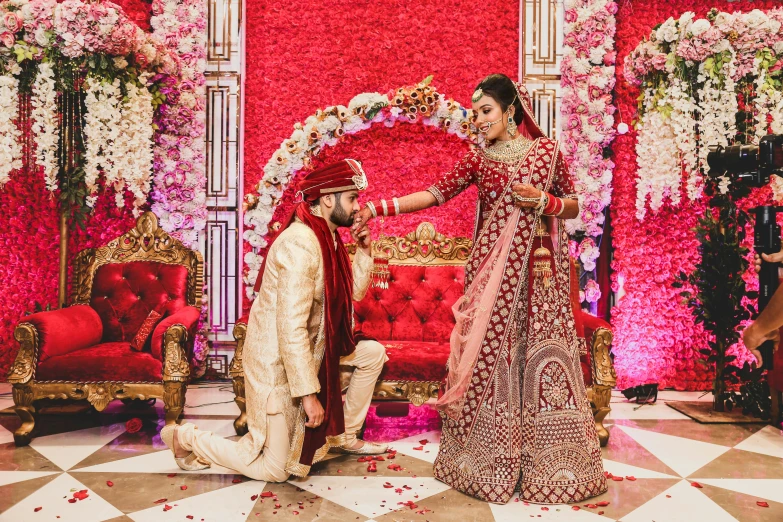 a bride and groom getting ready for their wedding ceremony, pexels, hurufiyya, ornate and intricate backdrop, pink and red color scheme, they are crouching, featured