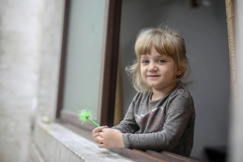 a little girl that is looking out of a window, holding a wand, photo of džesika devic, a friendly wisp, 15081959 21121991 01012000 4k